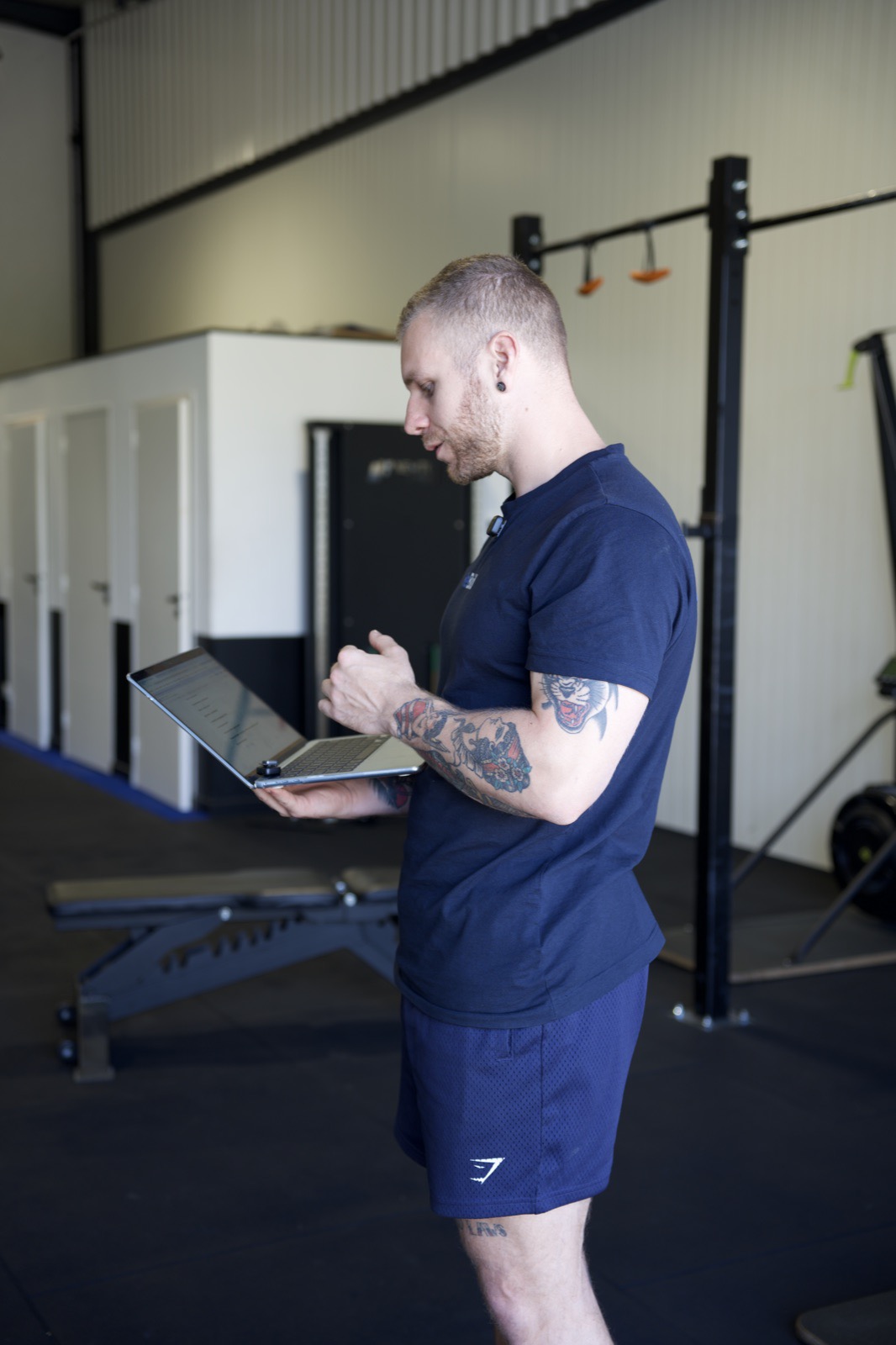 Antoine Quentin en salle de sport, ordinateur en main, pendant un suivi à distance